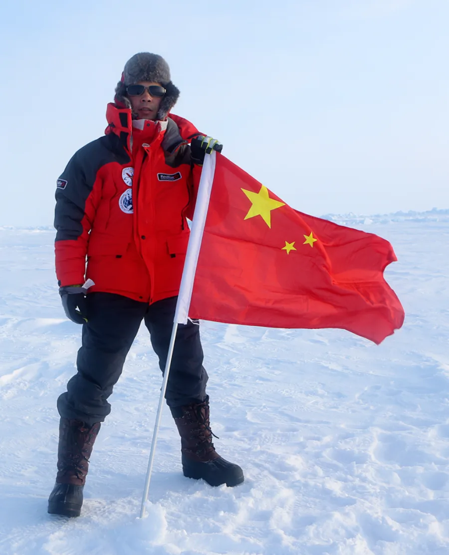 Danny Du holding a Chinese flag in the polar region