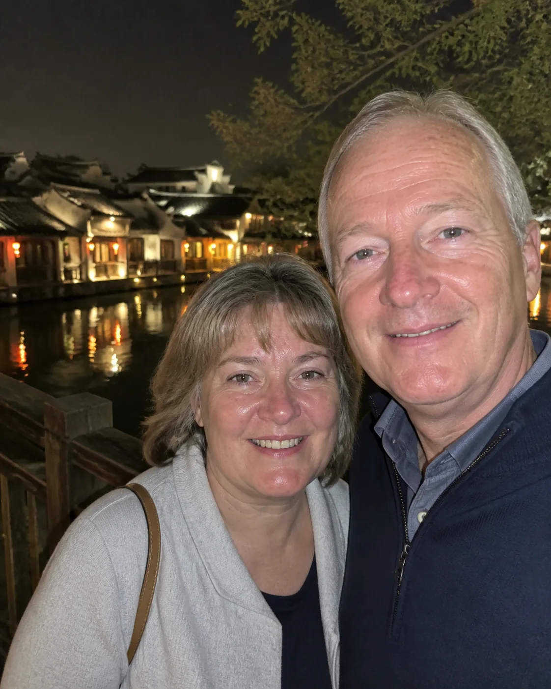 Joy Traveller guests by a historic water town at night